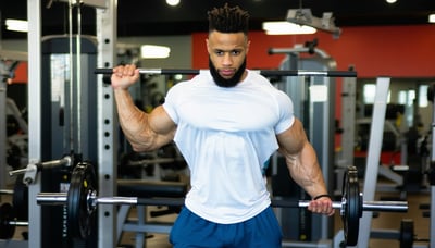 Certified personal trainer assisting a client with strength training at DMV Fitness